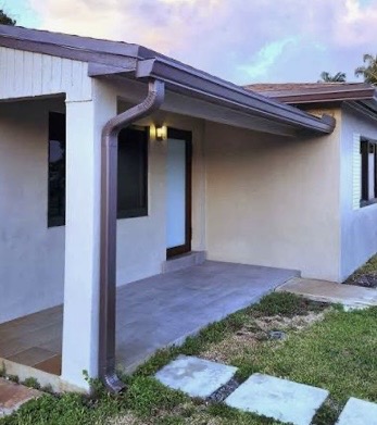Bronze downspout and gutter on a stucco house